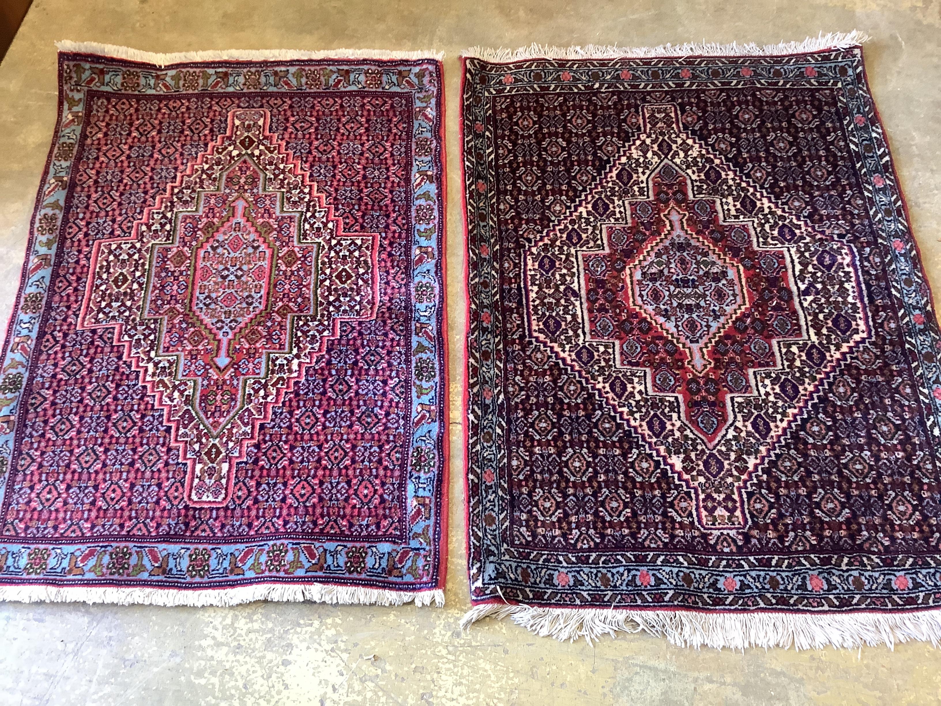 A near pair of Senneh blue ground mats, larger 104 x 77cm